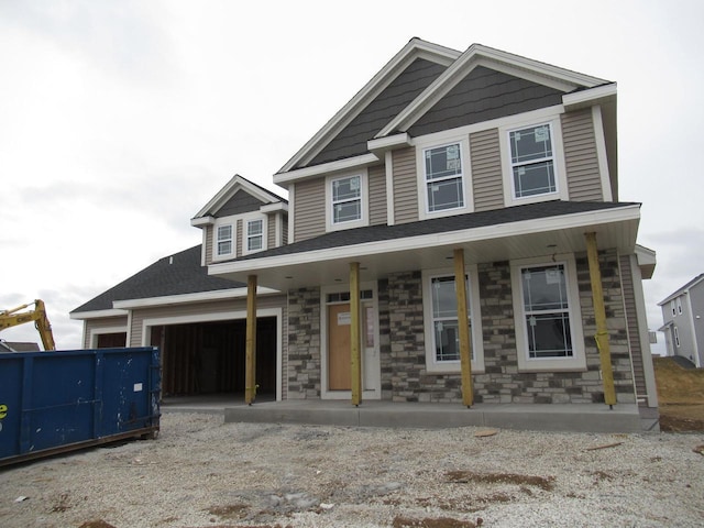 1581 Creekview Ln, Oconomowoc, WI 53066 - view of front facade featuring a porch, a garage, driveway, and stone siding