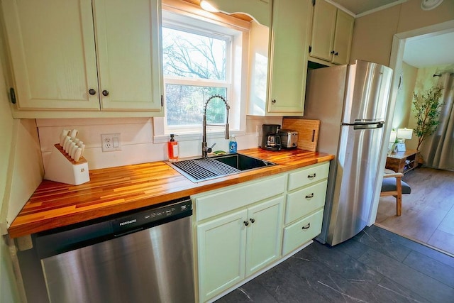 kitchen with sink, appliances with stainless steel finishes, tasteful backsplash, dark wood-type flooring, and wood counters