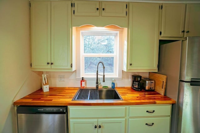 kitchen featuring wooden counters, appliances with stainless steel finishes, and sink