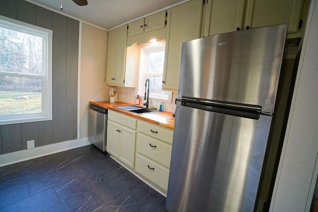 kitchen with a healthy amount of sunlight, stainless steel appliances, sink, and butcher block countertops