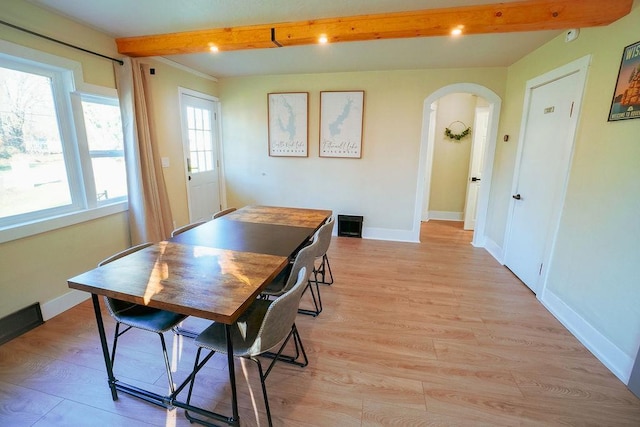 dining room featuring beamed ceiling and light hardwood / wood-style floors