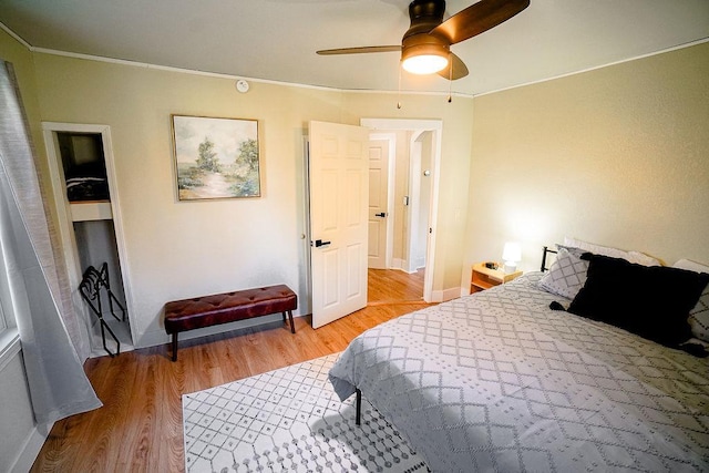 bedroom featuring ornamental molding, light hardwood / wood-style flooring, and ceiling fan