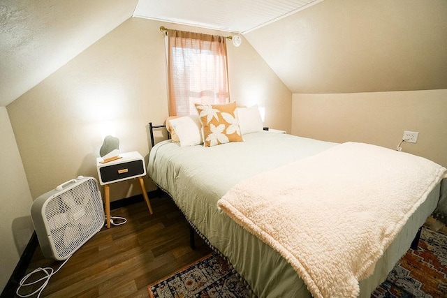 bedroom with dark wood-type flooring and lofted ceiling