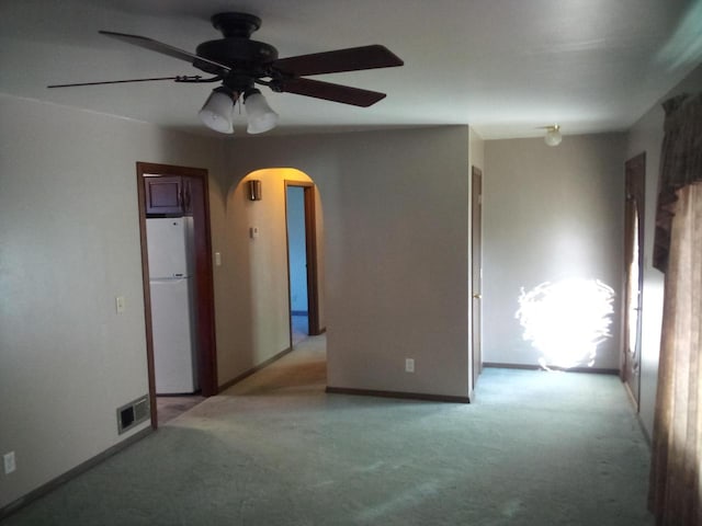 empty room with ceiling fan and light colored carpet