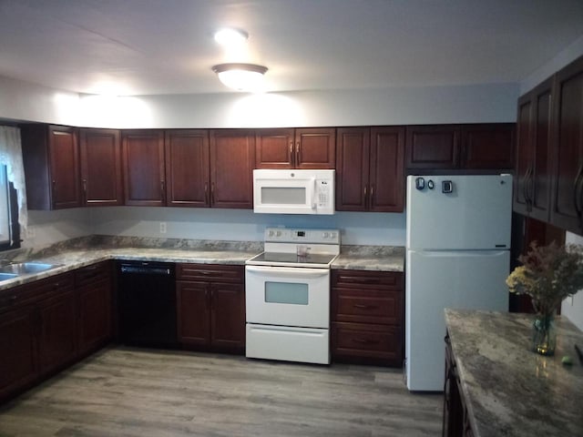 kitchen featuring light wood-type flooring, sink, and white appliances