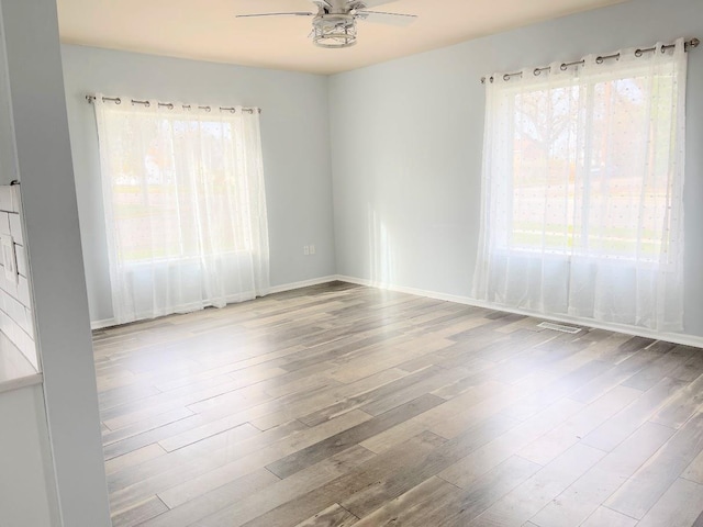 spare room with hardwood / wood-style flooring and ceiling fan