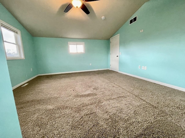 spare room featuring carpet, ceiling fan, and vaulted ceiling