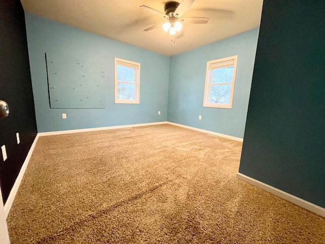 carpeted spare room with ceiling fan and plenty of natural light