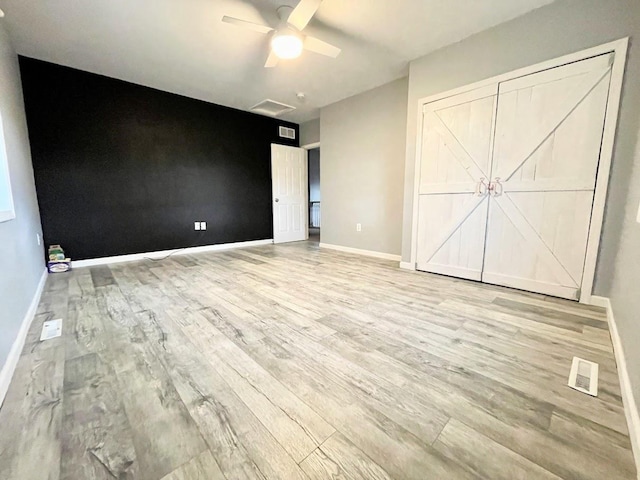 unfurnished bedroom with ceiling fan and light hardwood / wood-style flooring