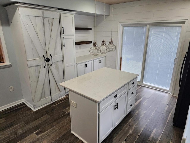 kitchen with dark wood-type flooring, a kitchen island, and white cabinetry