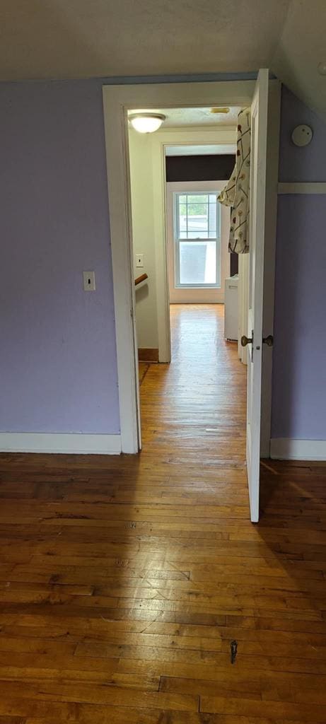 corridor featuring lofted ceiling and wood-type flooring