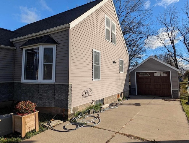 view of side of home featuring a garage and an outdoor structure