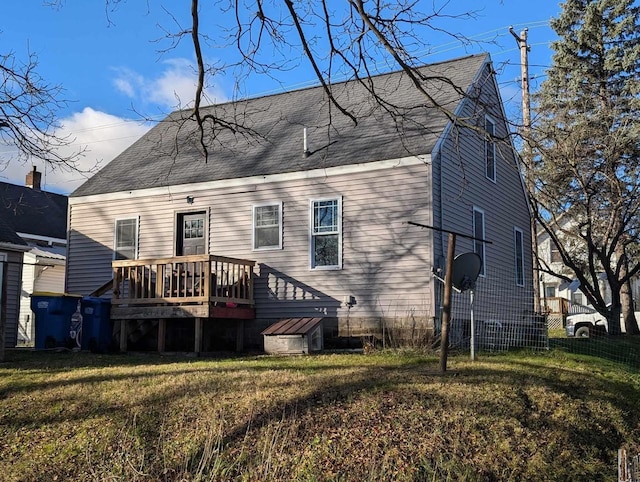 back of property featuring a lawn and a deck