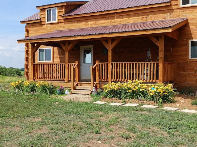 property entrance featuring a lawn and covered porch