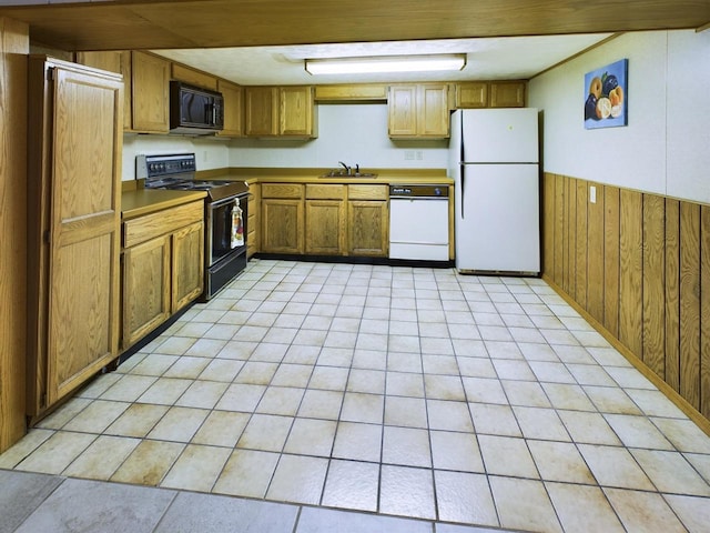 kitchen featuring black appliances, wooden walls, and sink