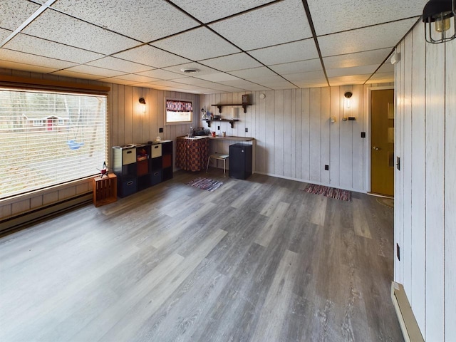 bar featuring wood walls, a paneled ceiling, and wood-type flooring