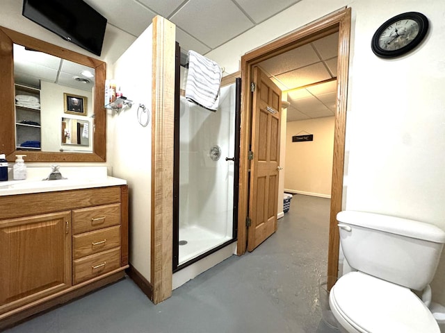 bathroom with toilet, a paneled ceiling, concrete flooring, vanity, and a shower