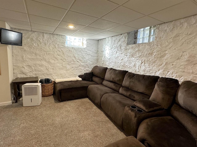 living room with a paneled ceiling and carpet