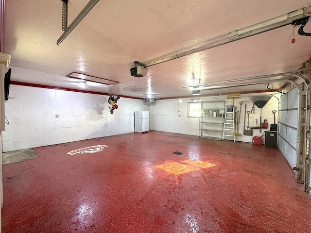 garage with a garage door opener and white refrigerator