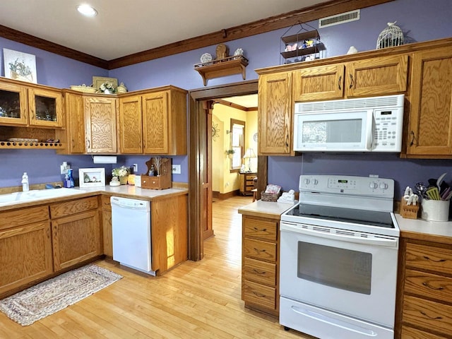 kitchen featuring white appliances, sink, light hardwood / wood-style flooring, and ornamental molding