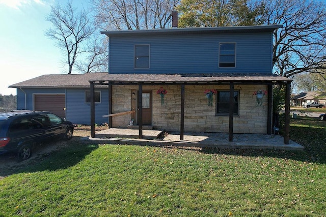 rear view of property with a lawn and a garage