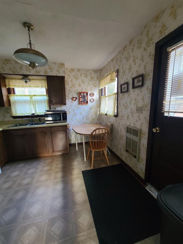 kitchen with decorative light fixtures, heating unit, sink, and parquet flooring