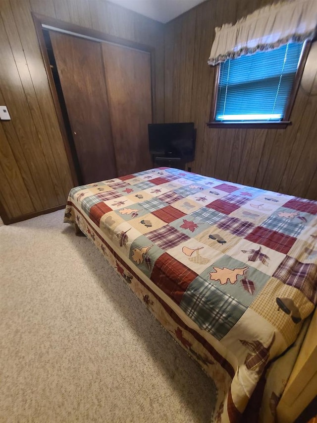 bedroom featuring carpet, wooden walls, and a closet