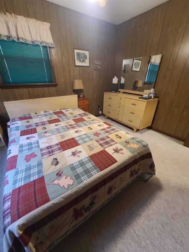 carpeted bedroom featuring wood walls