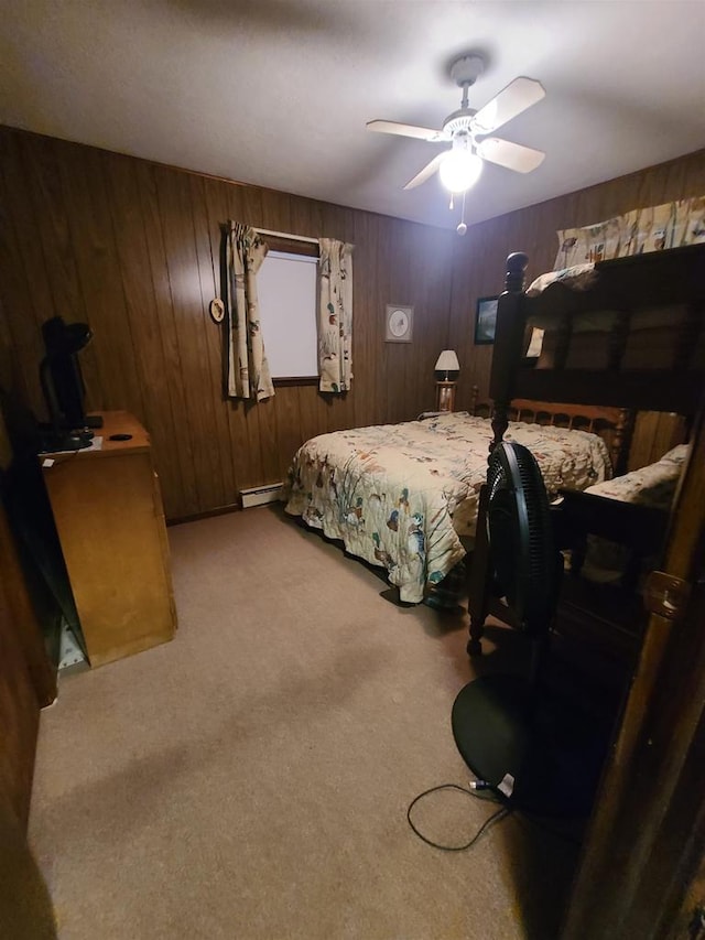 bedroom featuring ceiling fan, wooden walls, a baseboard radiator, and carpet floors