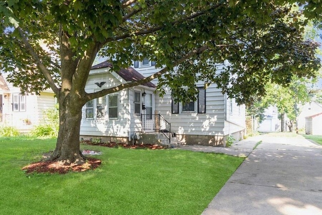 view of property hidden behind natural elements featuring a front lawn