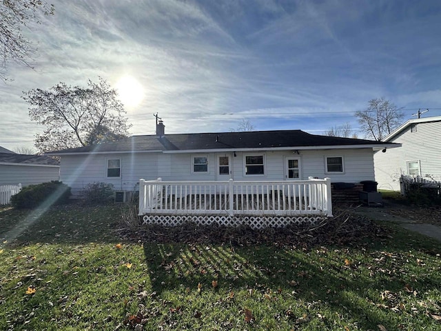 rear view of house featuring cooling unit, a yard, and a deck