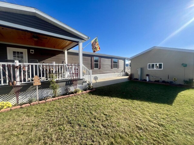 back of property with a wooden deck and a yard