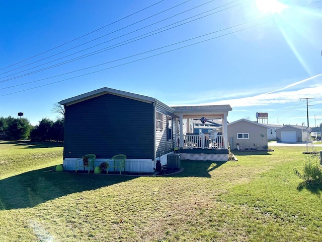 view of property exterior featuring a deck, a garage, central AC, and a yard