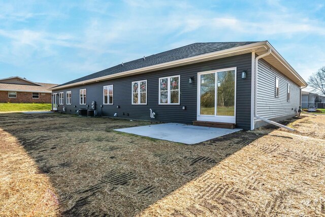 back of house featuring central AC unit, a patio, and a lawn