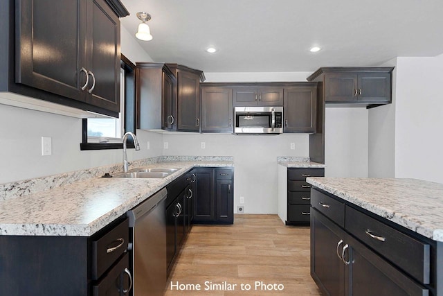 kitchen featuring dark brown cabinetry, appliances with stainless steel finishes, sink, and light hardwood / wood-style flooring