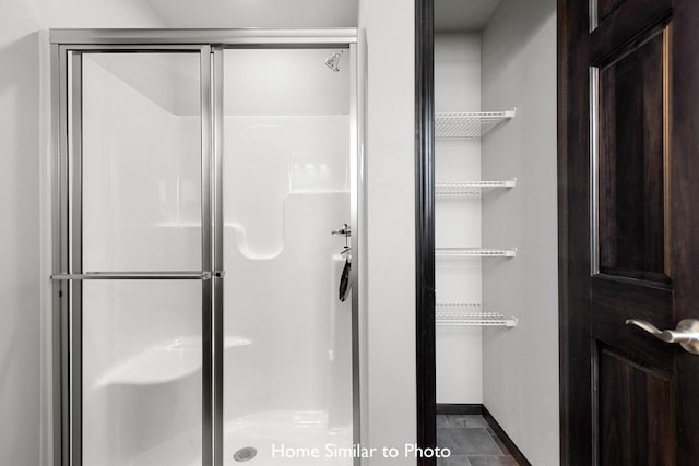 bathroom with tile patterned flooring and a shower with shower door