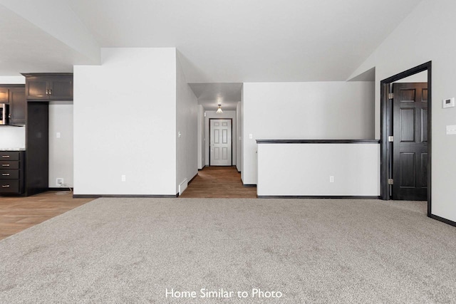 unfurnished living room featuring wood-type flooring and lofted ceiling