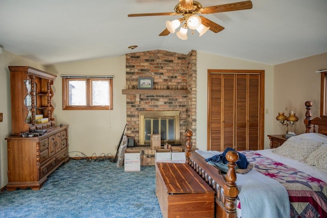 carpeted bedroom with a fireplace, ceiling fan, a closet, and vaulted ceiling