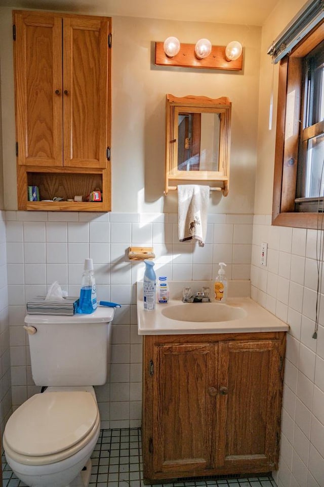 bathroom featuring tile patterned floors, vanity, toilet, and tile walls