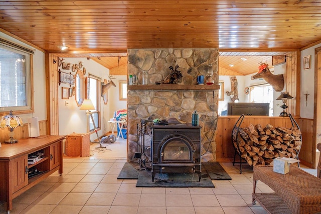 interior space featuring tile patterned floors, a wood stove, and wood ceiling