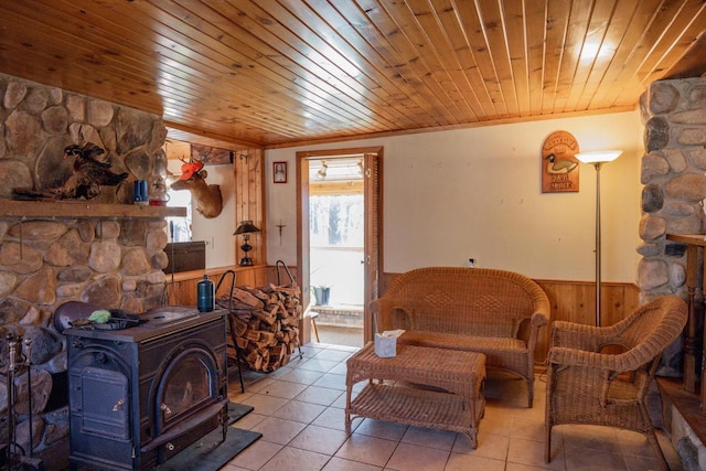 tiled living room with wood walls, a wood stove, ornamental molding, and wood ceiling