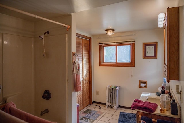 bathroom featuring tile patterned floors, radiator heating unit, and shower / tub combination