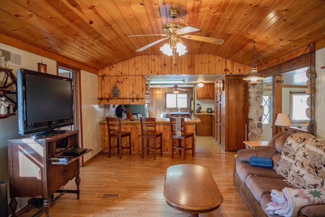 living room with light wood-type flooring, vaulted ceiling, and a healthy amount of sunlight