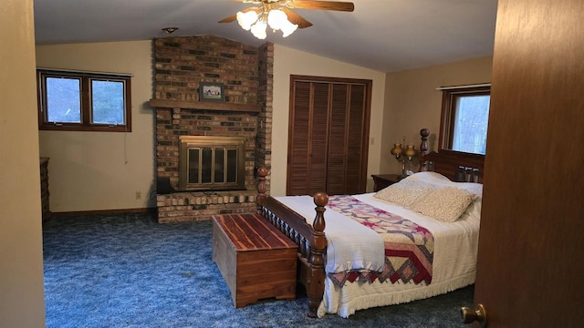 carpeted bedroom with a fireplace, a closet, vaulted ceiling, and ceiling fan