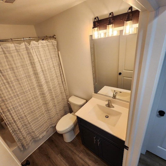 full bathroom with hardwood / wood-style floors, vanity, toilet, and shower / bath combination with curtain