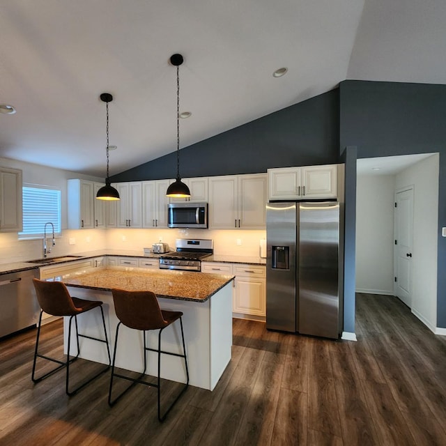 kitchen featuring a center island, sink, light stone countertops, white cabinetry, and stainless steel appliances