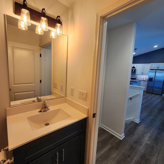 bathroom with vanity, wood-type flooring, and lofted ceiling