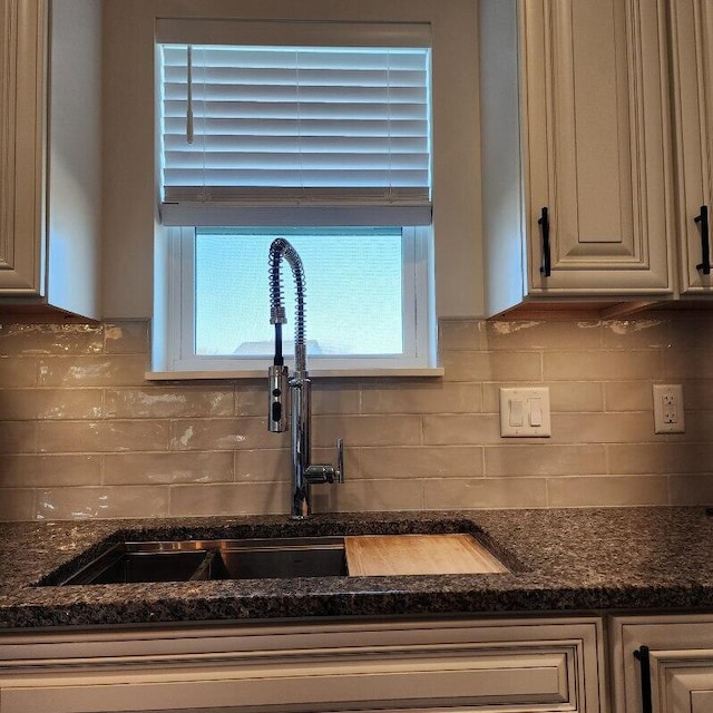 kitchen with tasteful backsplash, sink, and dark stone counters