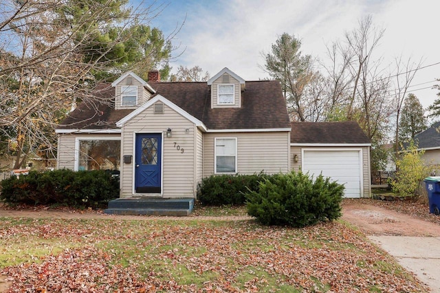 cape cod home featuring a garage