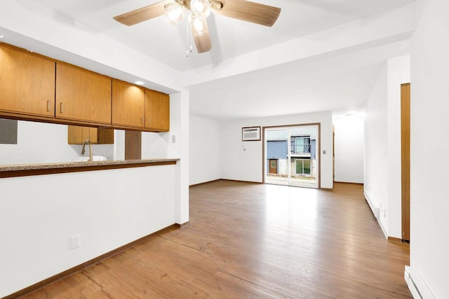 unfurnished living room featuring light wood-type flooring, ceiling fan, and an AC wall unit